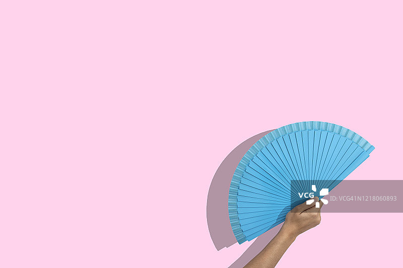 粉色背景上的蓝色折扇图片素材