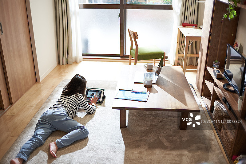 女孩躺着看平板电脑图片素材