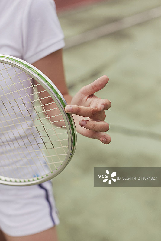手和手指放在复古网球拍边缘的特写图片素材