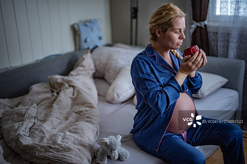 在家中手拿茶杯的孕妇图片素材
