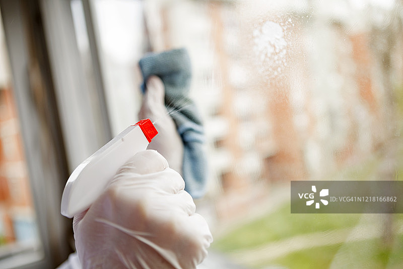 年轻女人清洁公寓的窗户图片素材