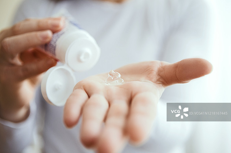 年轻女人在手上涂抹抗菌洗手液图片素材