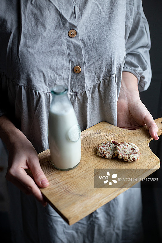女人手中的杏仁素食牛奶和无麸质饼干图片素材