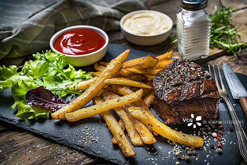 烤里脊肉配炸薯条和沙拉图片素材