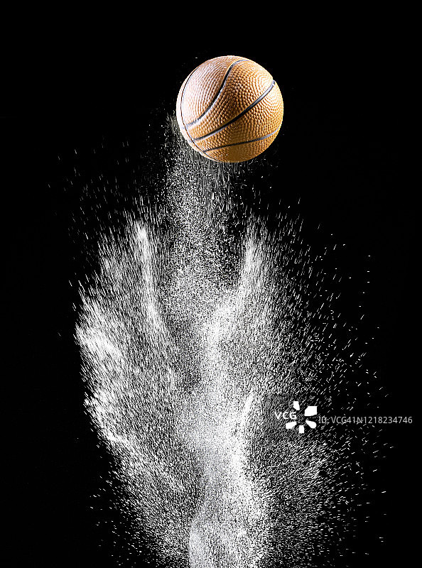篮球在黑色背景的土地和粉末表面上的撞击和反弹图片素材