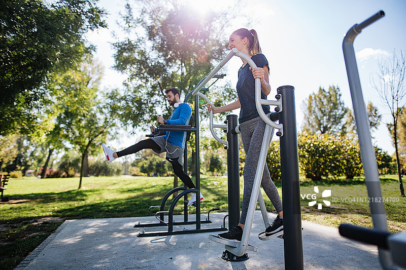 在户外健身房锻炼的运动情侣图片素材