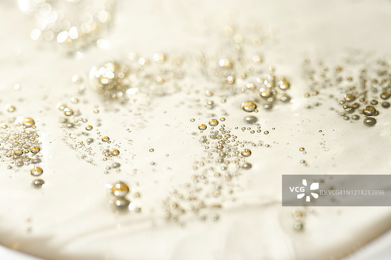 浅黄色背景上的透明气泡啫喱霜。透明质酸液体凝胶（俯视）图片素材