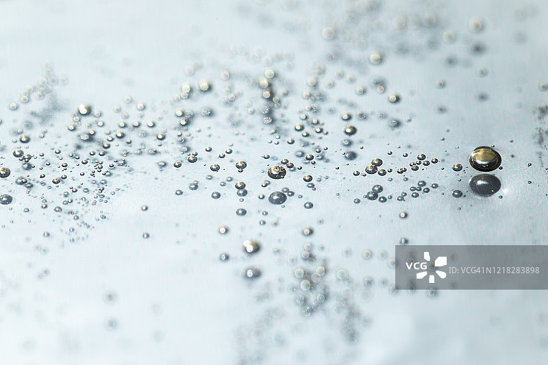 浅蓝色背景上的透明气泡凝胶霜：液态透明质酸凝胶，俯视图图片素材