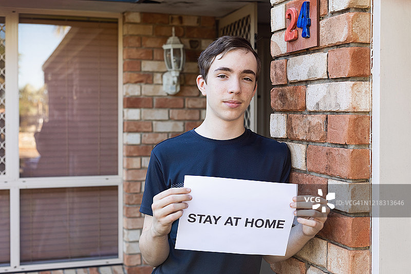 拿着居家标语的青少年男孩图片素材