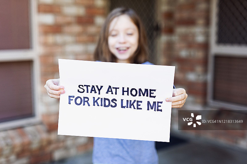 拿着居家隔离标语的年轻女孩图片素材