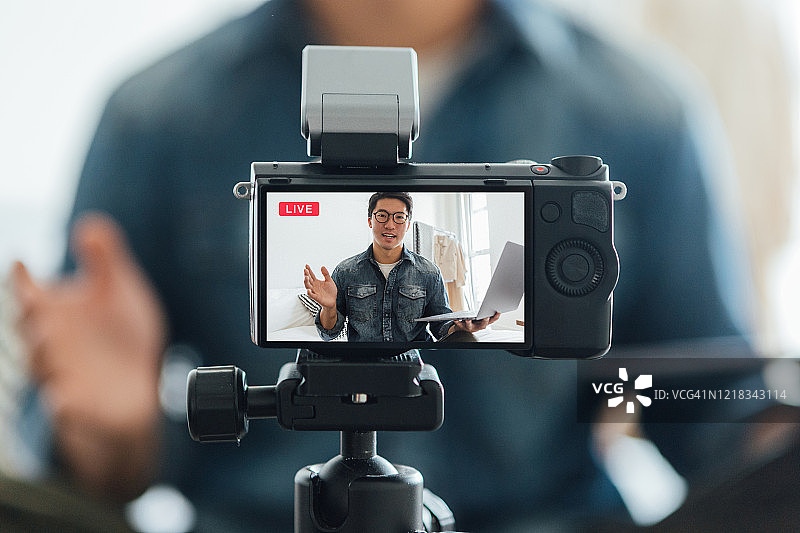 年轻男人在家通过摄像机录制视频博客图片素材