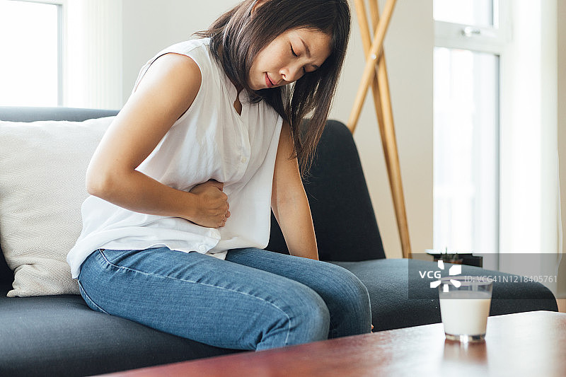 年轻女人在家中胃痛图片素材