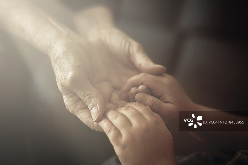 孙子紧握祖母的手的特写镜头图片素材