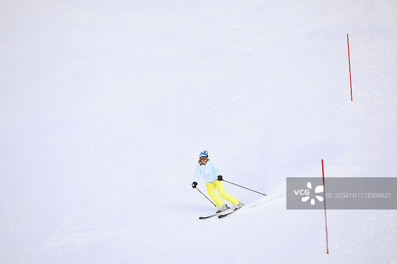 业余冬季运动：高山滑雪，女子在滑雪胜地滑雪，阿尔卑斯山雪景图片素材