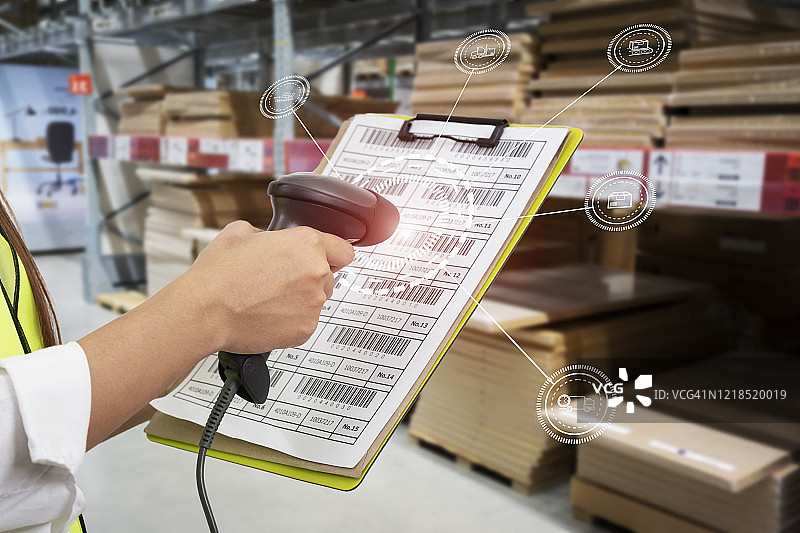 现代仓库前的条形码扫描器扫描纸板箱上的代码图片素材