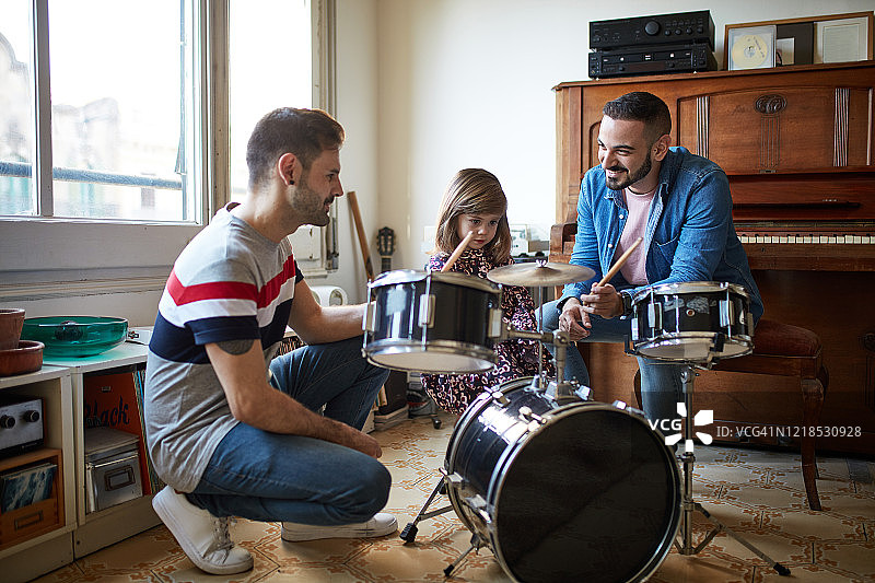 父亲看小女儿学打鼓图片素材