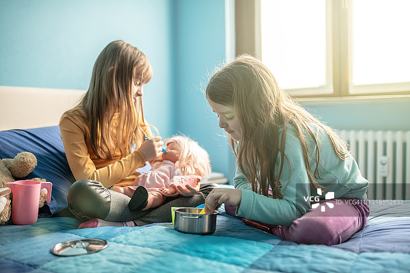 隔离期间姐妹在床上玩耍图片素材