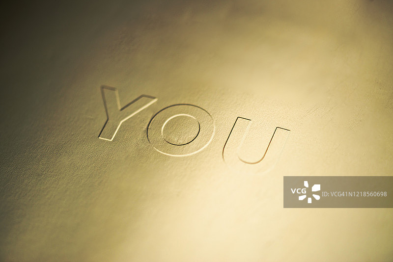 金色纸张凹版印刷单词“YOU”图片素材