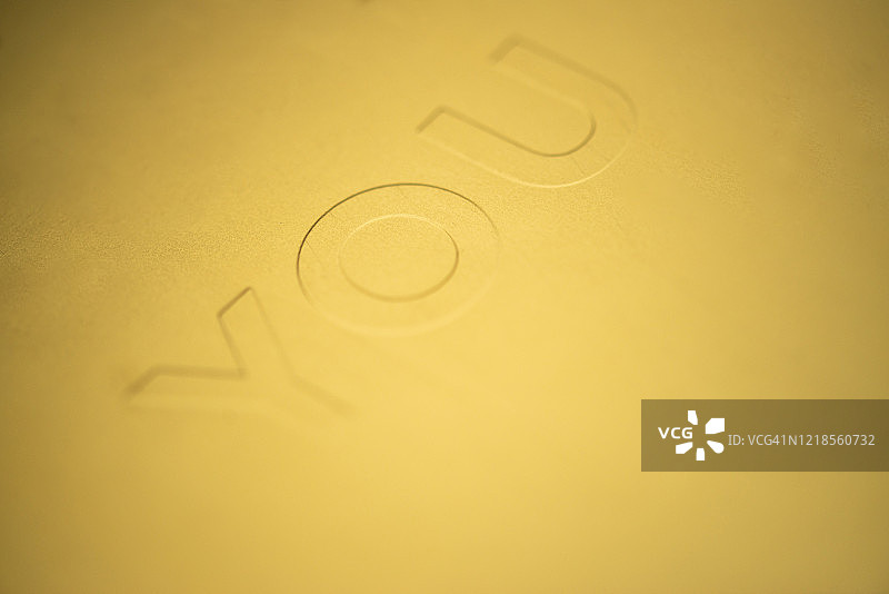 金色纸张上的“you”字样凹版印刷图片素材