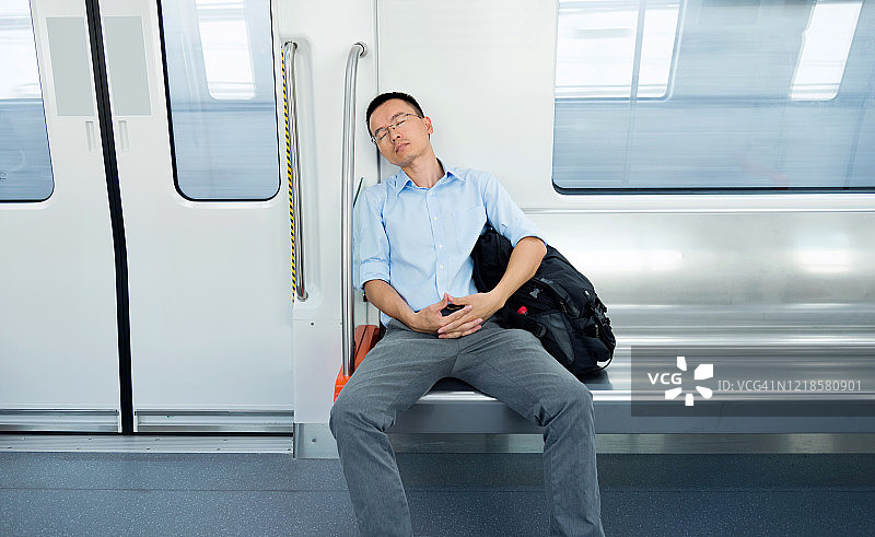 疲惫的商人在地铁车厢里睡觉图片素材