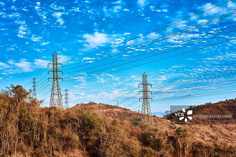 乡村景观中的高压电塔和粗电缆图片素材