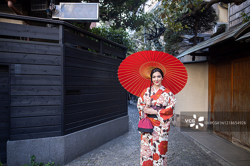 穿着和服的年长的白人妇女走在日本传统小巷上图片素材