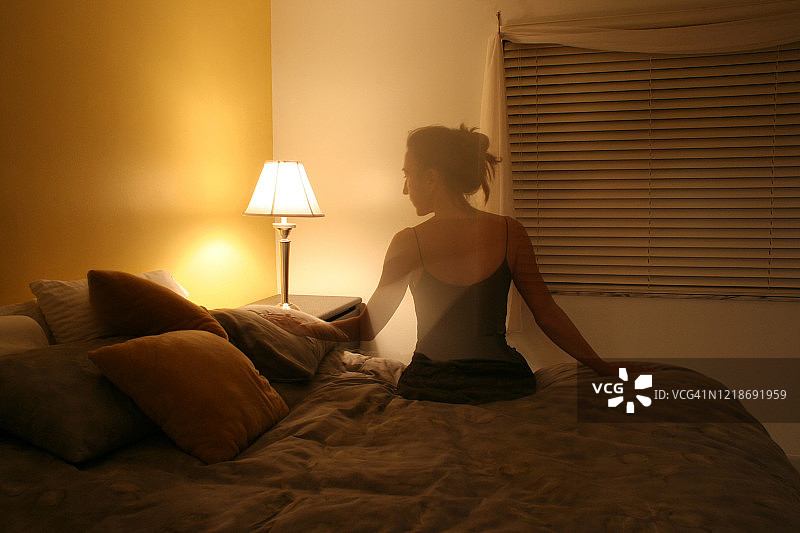 坐在床上的女性剪影图片素材