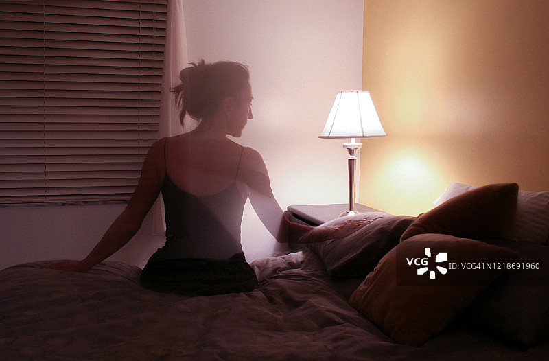 坐在床上的女性剪影图片素材