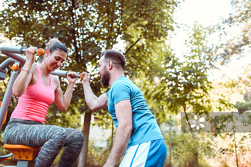 男人帮助可爱的女人进行户外锻炼图片素材