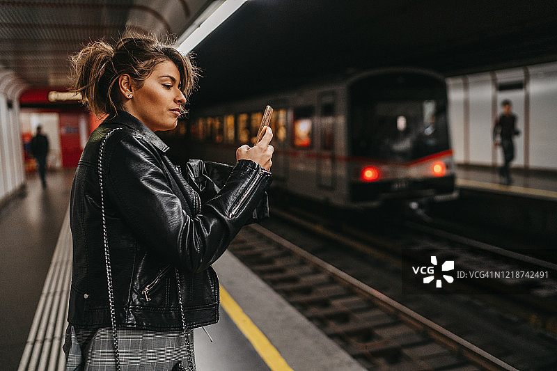 年轻女人在地铁里发短信图片素材