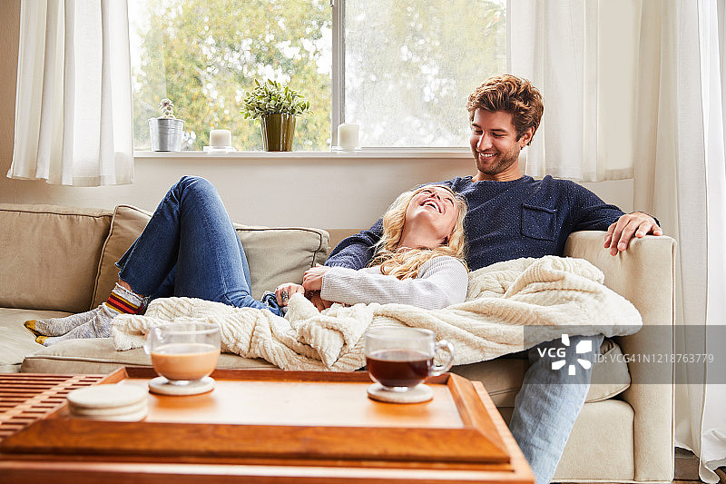 年轻夫妇在客厅沙发上放松交谈图片素材