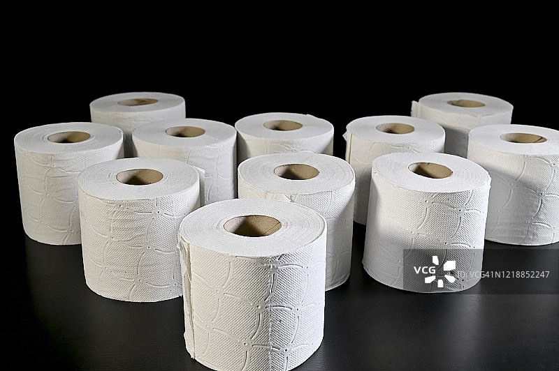 黑色桌子上的卫生纸卷，收纳概念图片素材