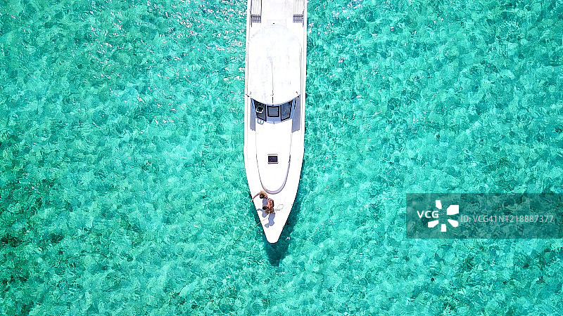 俯视：情侣在蓝色大海的游艇上放松，享受奢华假期图片素材