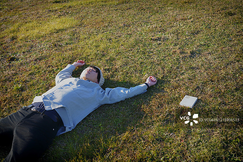 男人在阳光下躺在草地上图片素材