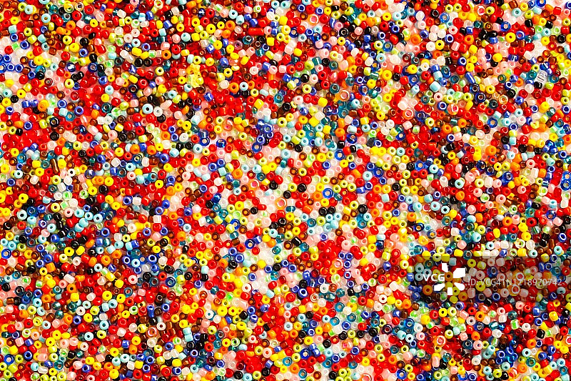 白色手工背景上彩色玻璃珠抽象背景特写图片素材
