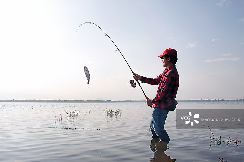 渔民在湖中用钓竿钓鱼图片素材