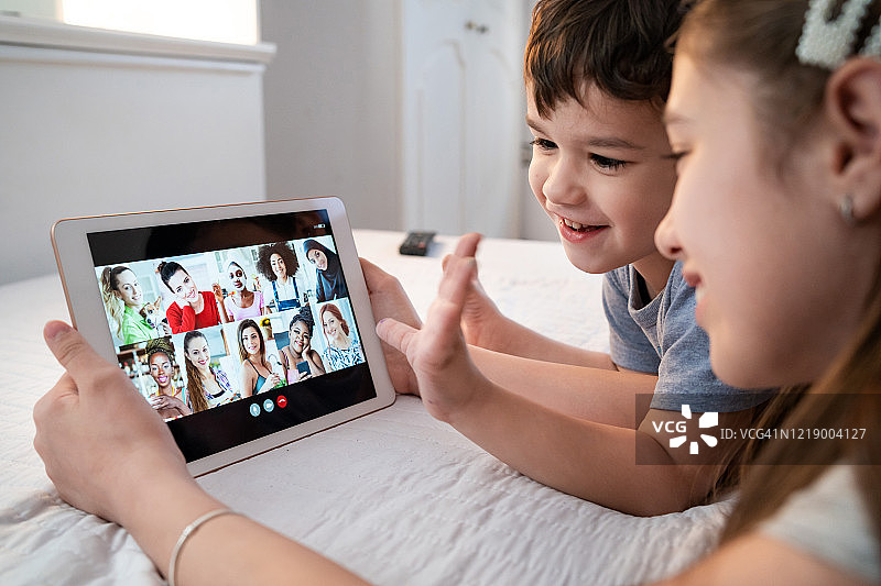 隔离期间孩子们在家使用平板电脑进行电话会议图片素材