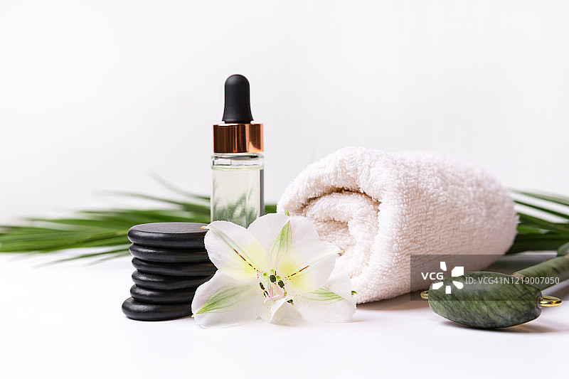 水疗用品套装：毛巾、按摩石、面部按摩器和香薰精油图片素材