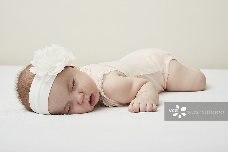白色背景上的睡梦中的新生婴儿图片素材
