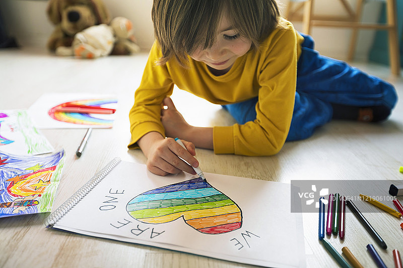 快乐的男孩在家画爱心，希望概念，新冠疫情图片素材