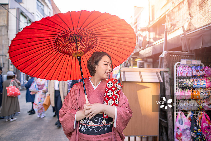 身穿和服的年轻女子在日本传统商业街购物图片素材