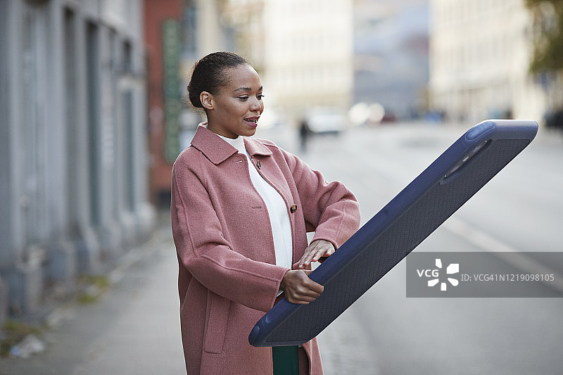 女人站在人行道上使用大屏手机图片素材