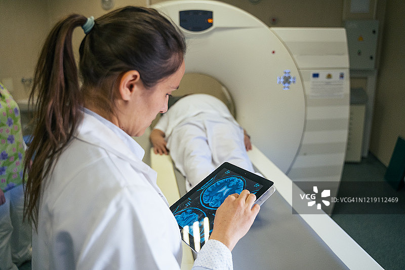 放射科医生准备医疗扫描仪，与患者交谈并帮助他为手术做好准备图片素材