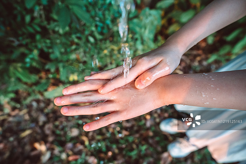 在公园里洗手的小女孩的俯视图图片素材