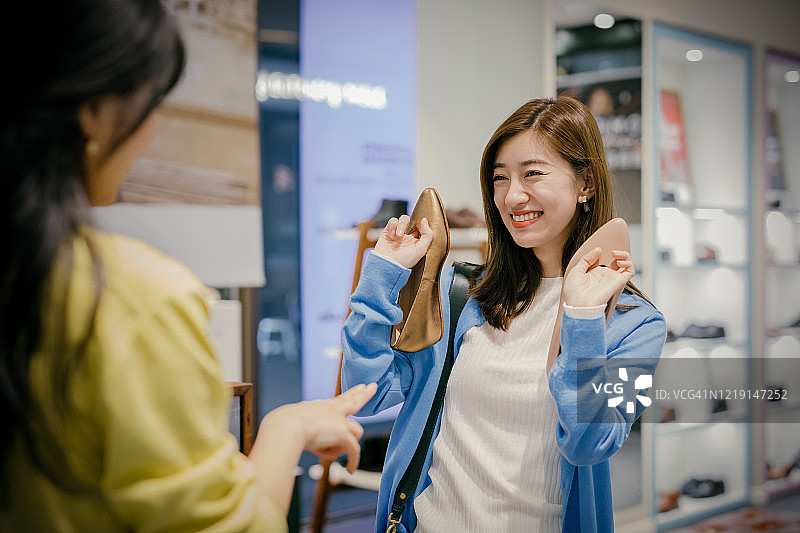 两位亚洲女性在鞋店挑选新鞋图片素材