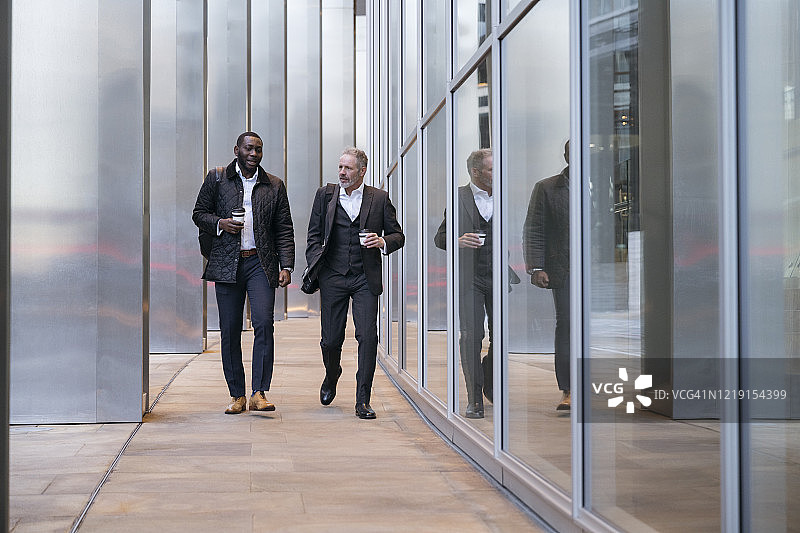 商务伙伴在咖啡休息时间边走边谈图片素材