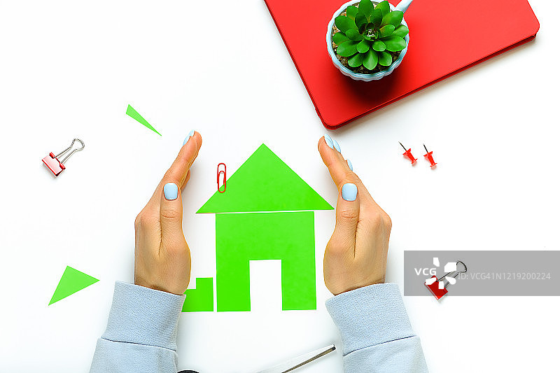 女人手中的彩色剪纸小屋图片素材