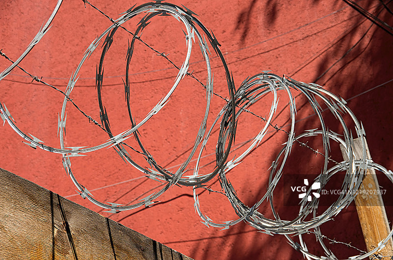 建筑工地周围胶合板围栏上方的刀片刺网和铁丝网图片素材