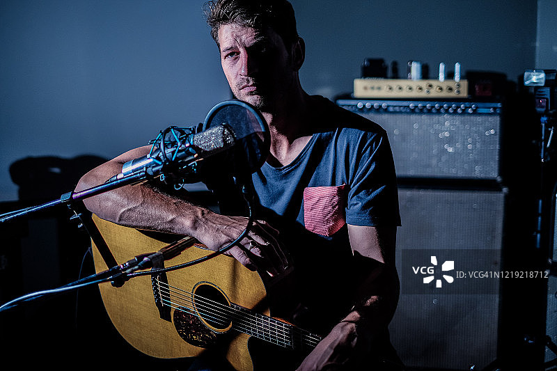 音乐家看着相机，戏剧性的侧光图片素材