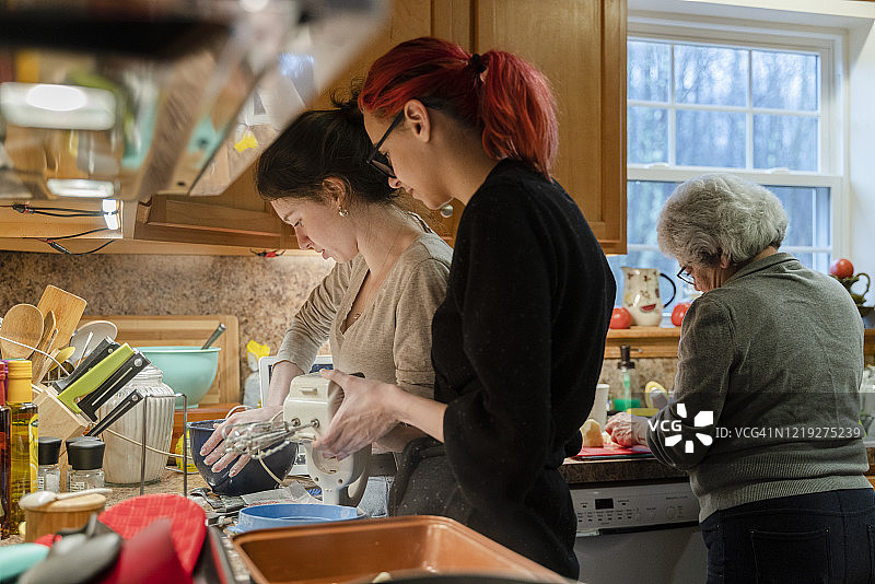 少女帮助她的妹妹混合馅饼面糊图片素材